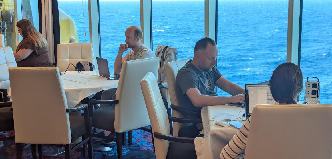 Writing by the Ocean A writer's laptop screen with a sun setting on open ocean behind it.